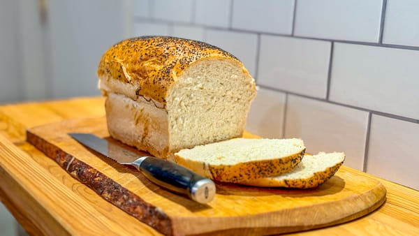 Photo of a partially sliced loaf of white bread.